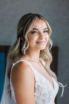 a woman in a wedding dress smiles at the camera