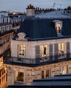 an apartment building is lit up at night with the city lights shining on it's windows