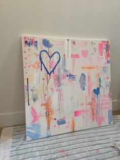 an abstract painting on canvas with blue heart and pink paint splattered all over it