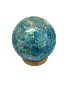 a blue marble ball sitting on top of a wooden base