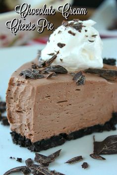 a piece of chocolate cream cheese pie on a plate with whipped cream and chocolate shavings