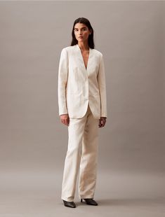 Made from a soft linen blend, this collarless blazer has a crisp, clean shape and a weightless feel. Styled with long sleeves and tailored with darts along the front. Created with hidden button closures, this blazer is a refined piece for an elevated wardrobe.  Material: 40% Cupro, 35% Linen, 25% Cotton. Tailored Linen Classic Pantsuit, Linen Blazer With Concealed Placket And Long Sleeves, Long Sleeve Linen Blazer With Concealed Placket, Linen Blazer With Concealed Placket, Linen Blazer With Concealed Placket For Work, Linen Blazer For Business Casual, Classic Linen Pantsuit For Formal Occasions, Business Casual Linen Blazer With Concealed Placket, Elegant Linen Suits For Fall