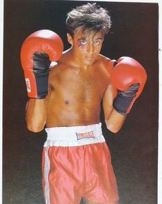 a young man wearing red boxing gloves