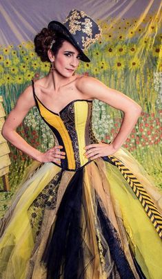 a woman in a yellow and black corset is posing for a photo with her hands on her hips