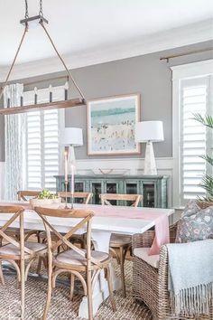 a dining room table with chairs and a chandelier hanging from it's ceiling