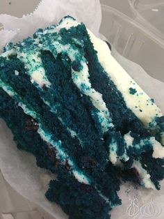 a piece of blue cake with white frosting