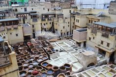 an aerial view of old buildings with lots of clay pots in the foreground and rooftops to the right