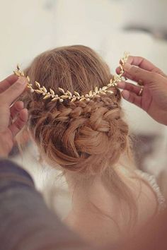 a woman is getting her hair done with some gold chains on top of her head