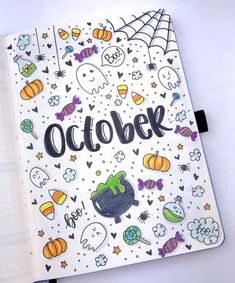 an open notebook with the word october written in black on it and lots of halloween doodles