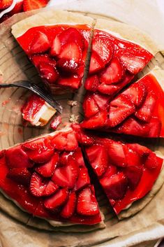 a sliced strawberry cake on a plate with a knife and fork next to the pie