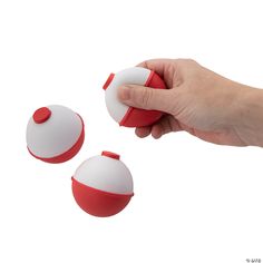 a hand holding a red and white object next to two other objects on a white background