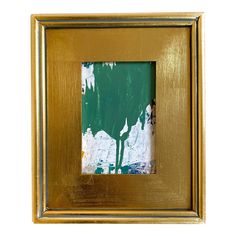 a gold frame with a green and white painting on it