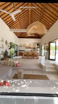 a living room filled with furniture and a ceiling fan in the middle of an open floor plan