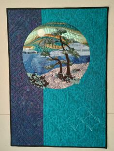 a quilted wall hanging with a tree on it