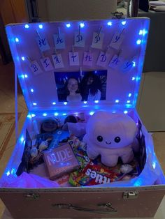 an open suitcase with pictures and lights on the inside is filled with candy, candies, and other items