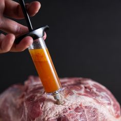 a person is using a meat grinder to cut up the meat on top of a large piece of meat