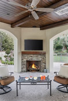 a living room with two chairs and a fire place in front of a tv mounted on the wall