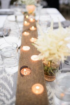 the table is set with candles and place settings for guests to sit down at it