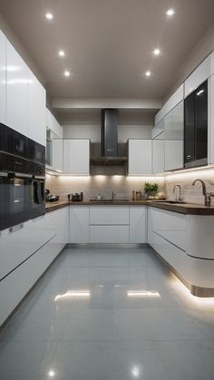 a large kitchen with white cabinets and black counter tops is lit by recessed lighting