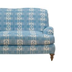 a blue and white couch with wooden legs