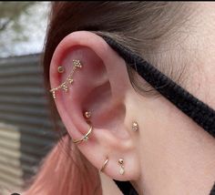 a close up of a person's ear with three different piercings on it