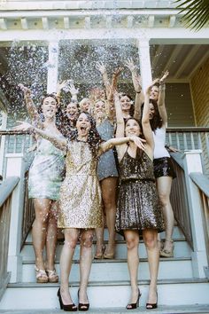 a group of young women standing on top of a set of stairs covered in confetti