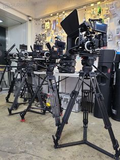 a bunch of cameras sitting on top of a tripod