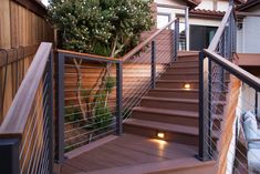 a set of stairs leading up to a house with lights on the steps and trees in the background