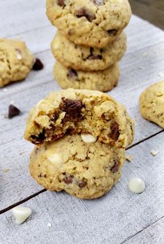 chocolate chip cookies stacked on top of each other with one broken in the middle and half eaten