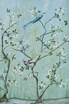 two birds sitting on top of a tree with white flowers in the foreground and a blue bird flying over it