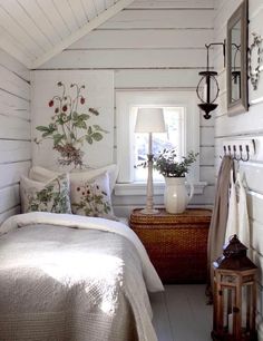 a bed sitting under a window next to a basket filled with flowers on top of it