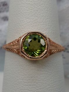 Natural Green Peridot Ring Dandelion Design#205 Custom This is a stunning Edwardian wedding reproduction gemstone filigree ring. The .85ct natural green peridot gemstone is 6mm in diameter. This lovely ring is 10K Rose Gold is marked 10K on the inner shank. Notice the beautiful craftsmanship of the rose gold filigree setting. This is an ornate and detailed ring. This is a lovely rendition of an Antique filigree wedding ring, and it is ready to wear. A ring gift box is included and all rings are Victorian Green Jewelry Stamped 14k, Art Deco Green Jewelry With Round Cut, Elegant Green Ceremonial Rings, Art Deco Green Round Cut Jewelry, Antique Green 14k Stamped Jewelry, Antique Green Jewelry Stamped 14k, Antique May Birthstone Rings For Wedding, Antique May Birthstone Wedding Rings, Victorian 14k Stamped Green Jewelry