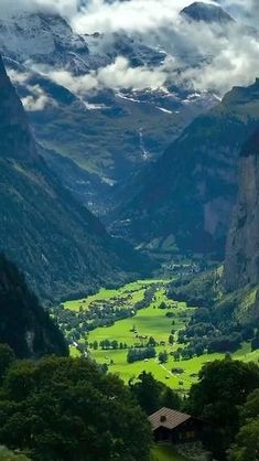 the valley is surrounded by mountains and trees