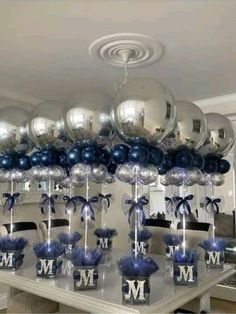 a table topped with lots of silver and blue balloons