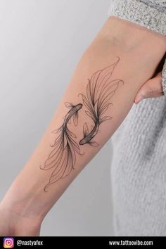 a woman's arm with a black and white tattoo design on the left forearm