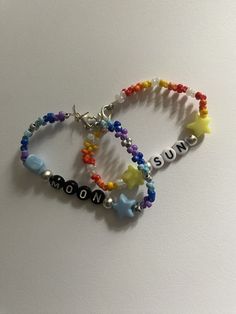 two bracelets that say sun and moon with beads around them on a white surface