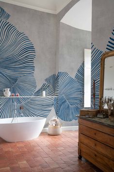 a bath room with a large white tub and a big mirror on the wall next to it