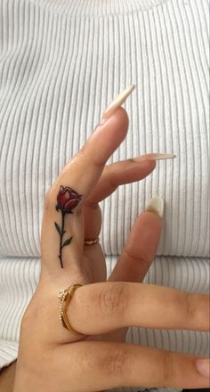 a woman with a rose tattoo on her finger