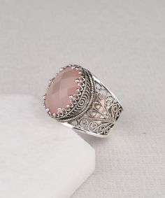 925 Sterling Silver Artisan Crafted Filigree Oval Statement Ring with Genuine Pink Chalcedony Gemstone Material: 925 Sterling Silver Genuine Pink Chalcedony Gemstone Dimensions : 16 mm x 12 mm Ring Face Length: 0.70 inches Width: 0.55 inches Comes with a gift pouch and box Free Domestic Shipping For this particular ring if desired We can change the stone to your favorite gem stone at a reasonable cost that is if the stone is not among what we are offering. Our fine silver jewelry is Made in our Elegant Moonstone Gemstone Ring As Gift, Elegant Silver Moonstone Ring Gift, Exquisite Handmade Rings As A Gift, Cabochon Filigree Ring Gift, Exquisite Silver Gemstone Rings, Elegant Pink Moonstone Sterling Silver Ring, Gift Moonstone Ring With Accent Stones In Sterling Silver, Exquisite Gemstone Filigree Ring As A Gift, Sterling Silver Filigree Ring With Gemstone For Gift