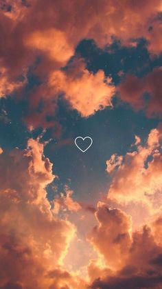 the sky is filled with clouds and a white heart