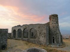 an old stone building sitting on top of a hill