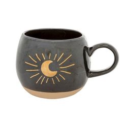 a ceramic mug with the sun and moon painted on it's side, sitting in front of a white background