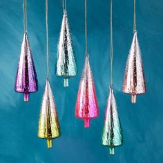 multicolored glass ornaments hanging from strings against a blue background in the shape of cones