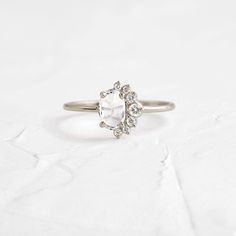 a white diamond ring sitting on top of a table