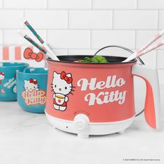 hello kitty ice cream maker and cups with straws in them sitting on a counter