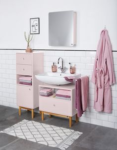 a bathroom with pink towels hanging on the wall and a sink in front of it