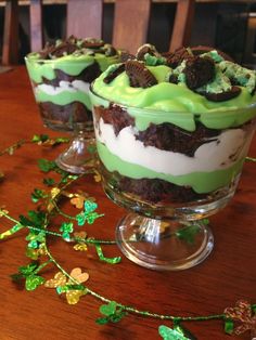 two desserts sitting on top of a table covered in green frosting and shamrock leaves