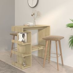 a wooden desk with two stools next to it and a clock on the wall