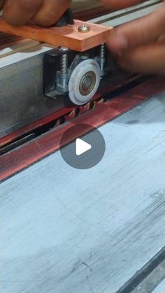 a person working on a piece of wood with a machine in the middle of it