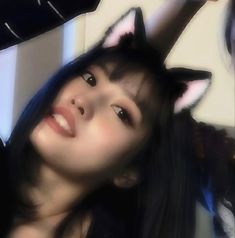 a woman with long black hair and cat ears on her head looking up at the ceiling